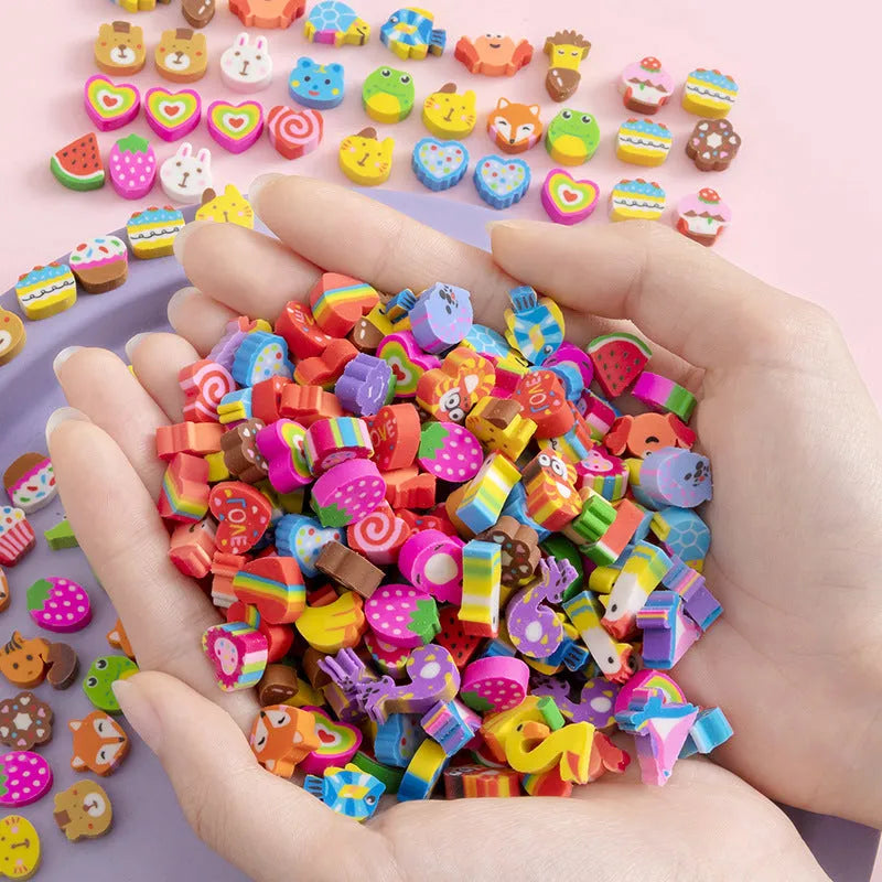 Assortment of colourful TPR cartoon mini erasers showing fruit, animal, and cake designs from a 50-piece pack.