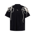 Black loose-fit short-sleeved t-shirt showing padded shoulder detail with rivet ribbon.