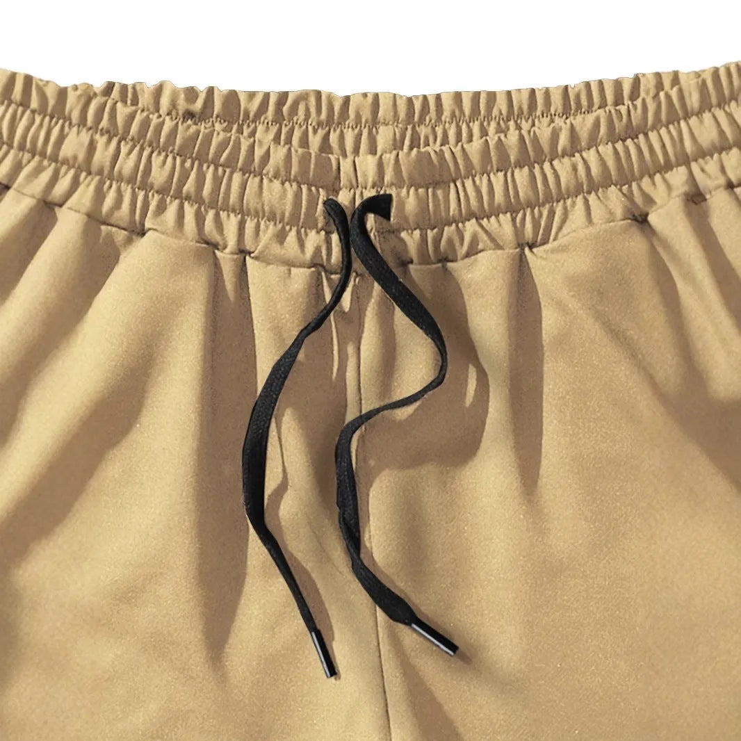 Men's khaki sports shorts with a coconut leaf pattern, showing a straight-leg fit and elasticated waistband.