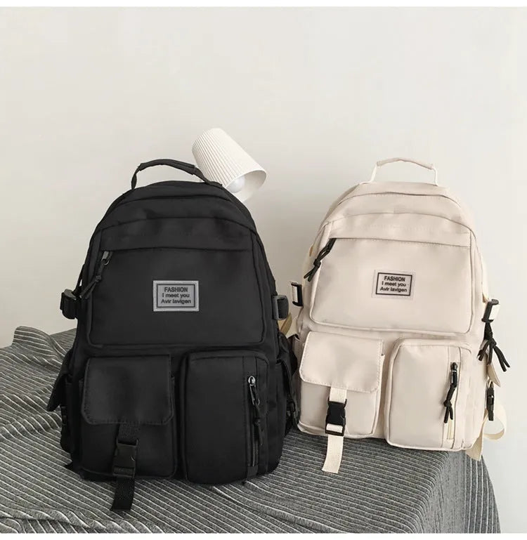Black and white soft nylon student backpack with laptop compartment and external pockets.