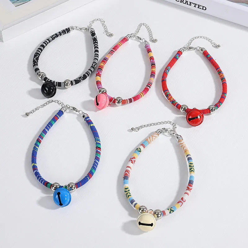 Coloured ethnic style adjustable pet collar with a bell for cats and dogs in black, blue, pink, red, and white.