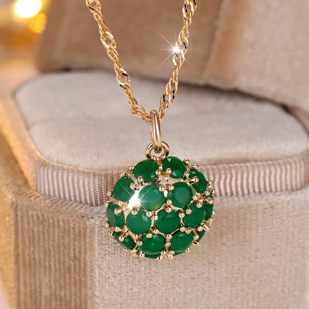 Geometric pendant necklace with emerald and diamond detailing on adjustable champagne gold chain