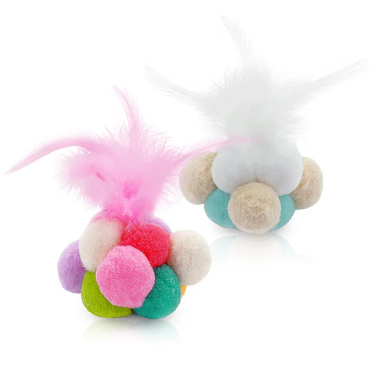 Colourful cat toy feather bouncy ball with pink feathers on a white background