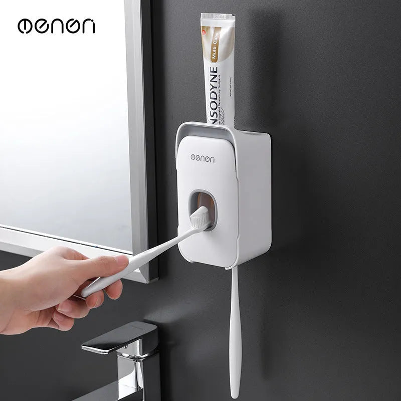 Automatic toothpaste dispenser unit mounted on a wall in a choice of blue, grey, or pink colours.
