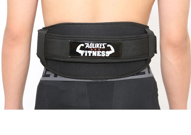 Black nylon fitness weightlifting belt on a gym floor, showing adjustable buckle and supportive width.