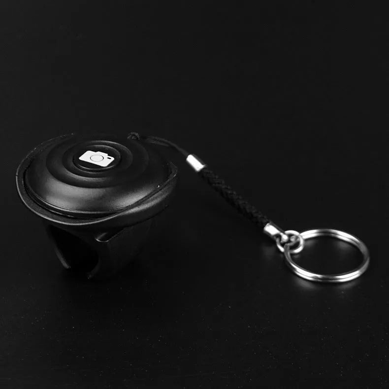 Black Bluetooth selfie remote control made of PC material weighing 27g with 10m range