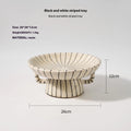 Black and white striped plastic resin dessert plate on a table.