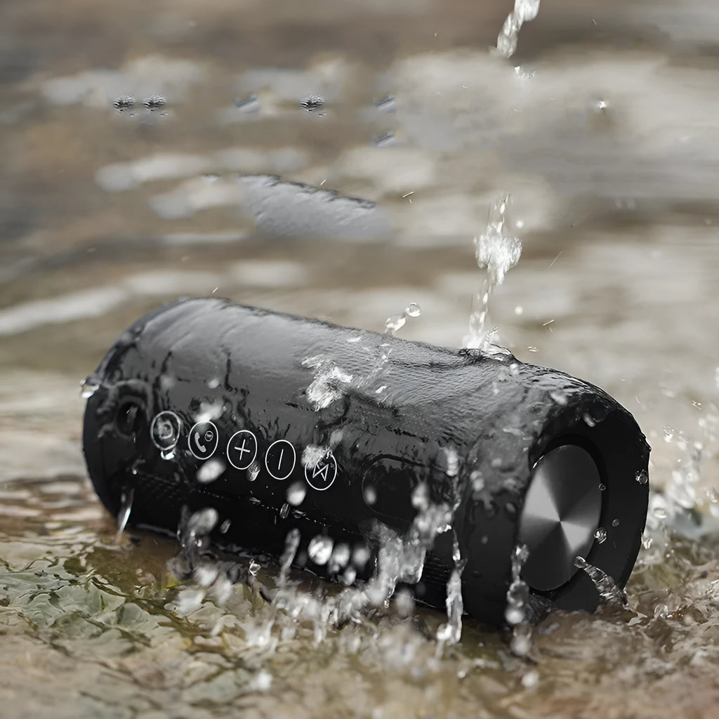 Black outdoor waterproof portable Bluetooth speaker on a grassy surface