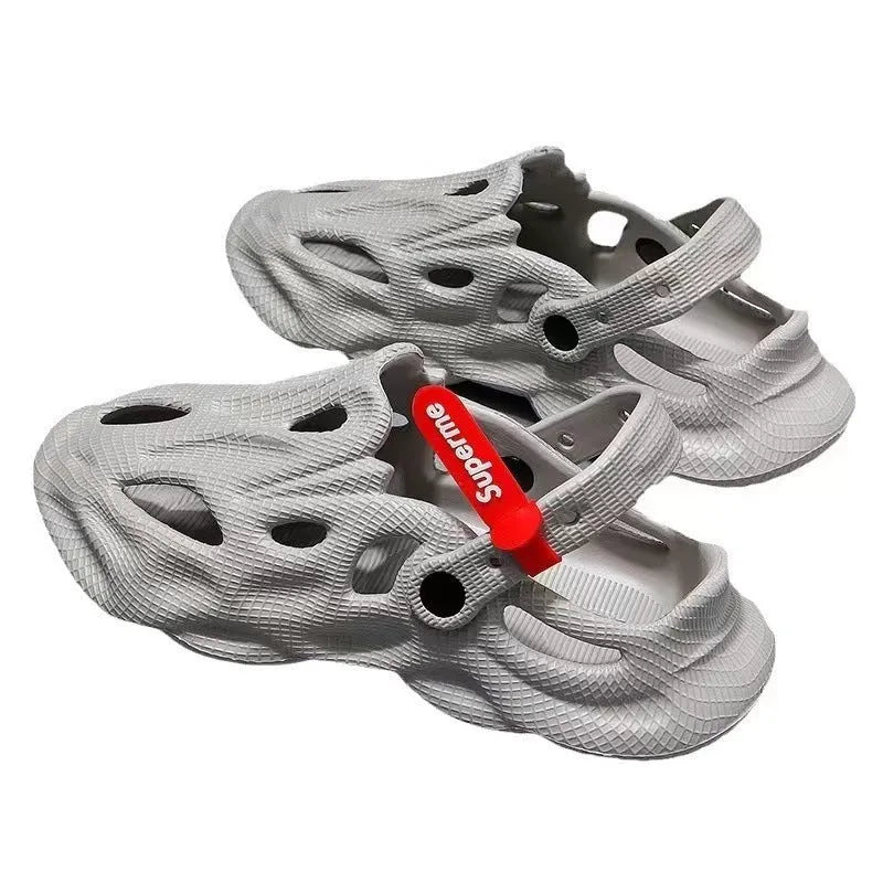 Pair of grey EVA foam closed-toe slippers on a sandy beach