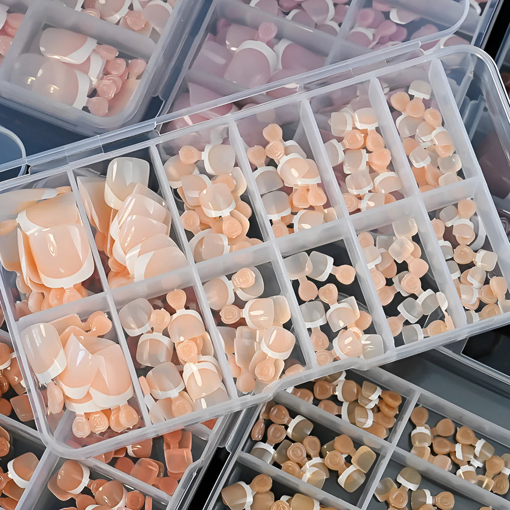 Box of 120 French white edge artificial toenails in square short shape, showing nine nude colour shades.
