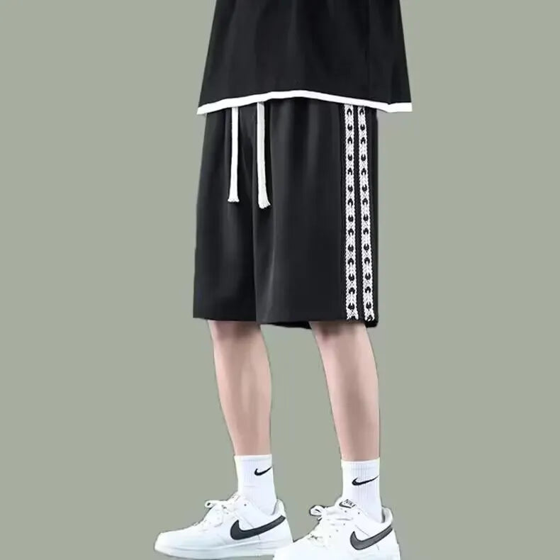Men's black baggy track pants with loose-fit design and elastic waistband