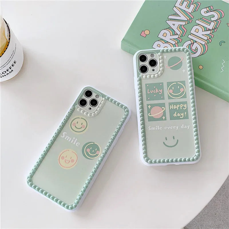 Green geometric pattern iPhone case with smiley faces and polka dot frames on a phone
