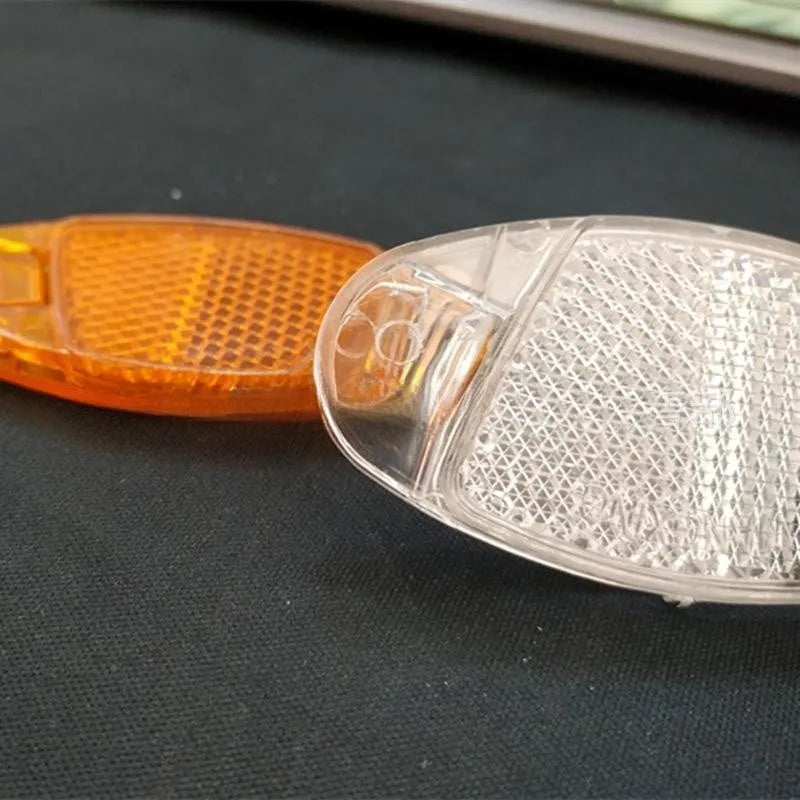 Set of four plastic bicycle spoke reflectors in yellow and white colours showing measurements
