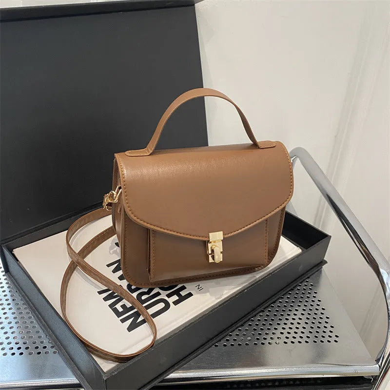 Retro style square messenger bag in PU with a crossbody strap and internal document pocket.
