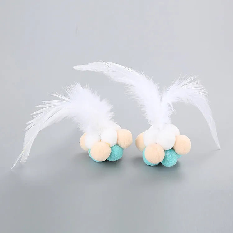 Colourful cat toy feather bouncy ball with pink feathers on a white background