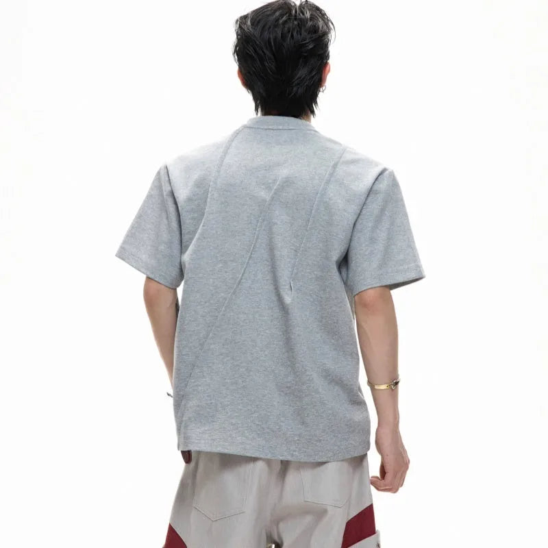 Men's grey cotton T-shirt with loose fit, round neck, and three-dimensional pleated detail on the front.