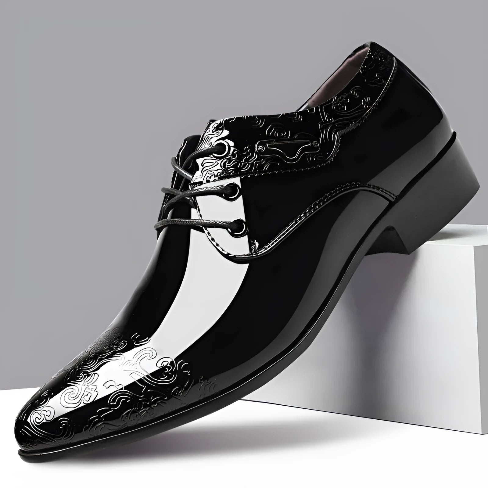 Men's glossy black patent leather formal shoes with pointed toe and carved detail, low top style