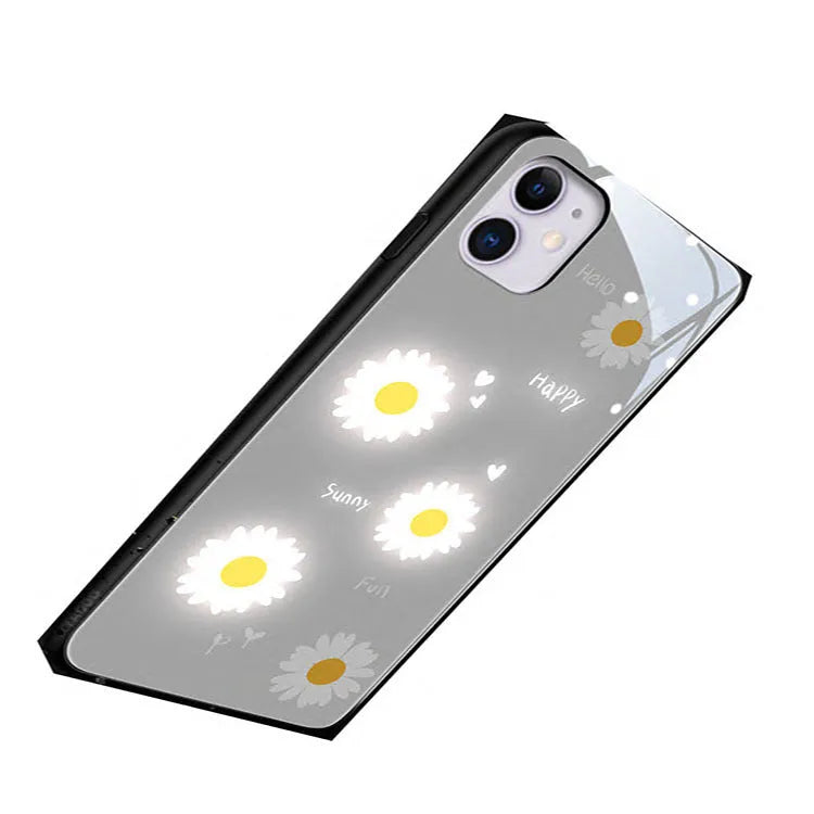 White iPhone case with painted purple daisies and lettering, illuminated with voice-activated colour-changing lights.