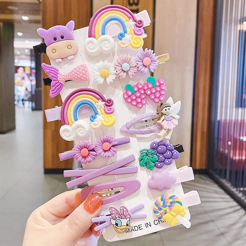 14-piece set of colourful toddler hair clips with candy, fruit, rainbow, and butterfly designs on a white background.