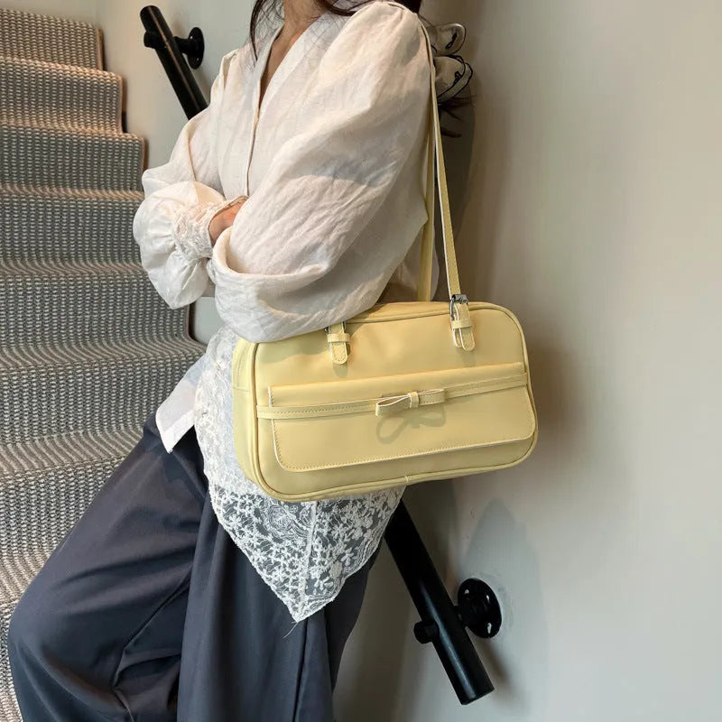 A horizontal square PU flap handbag in a solid colour with double-joint shoulder straps and optional pearl bow ornament.