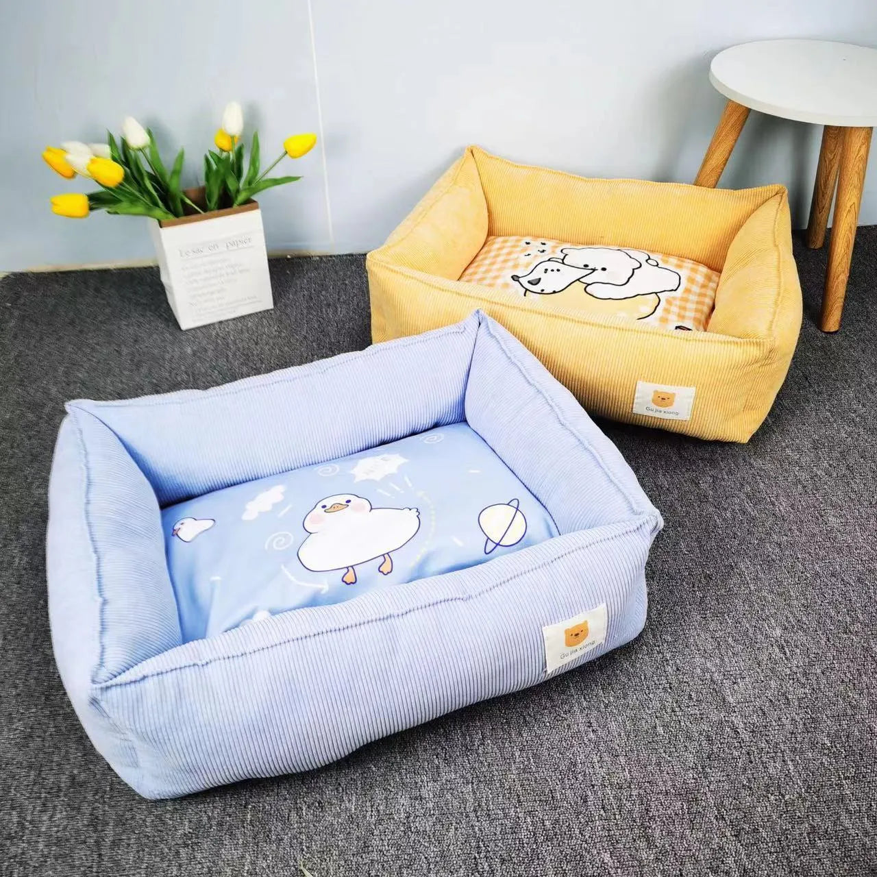 Light blue cotton winter dog nest bed with soft padded interior, shown empty on a wooden floor.