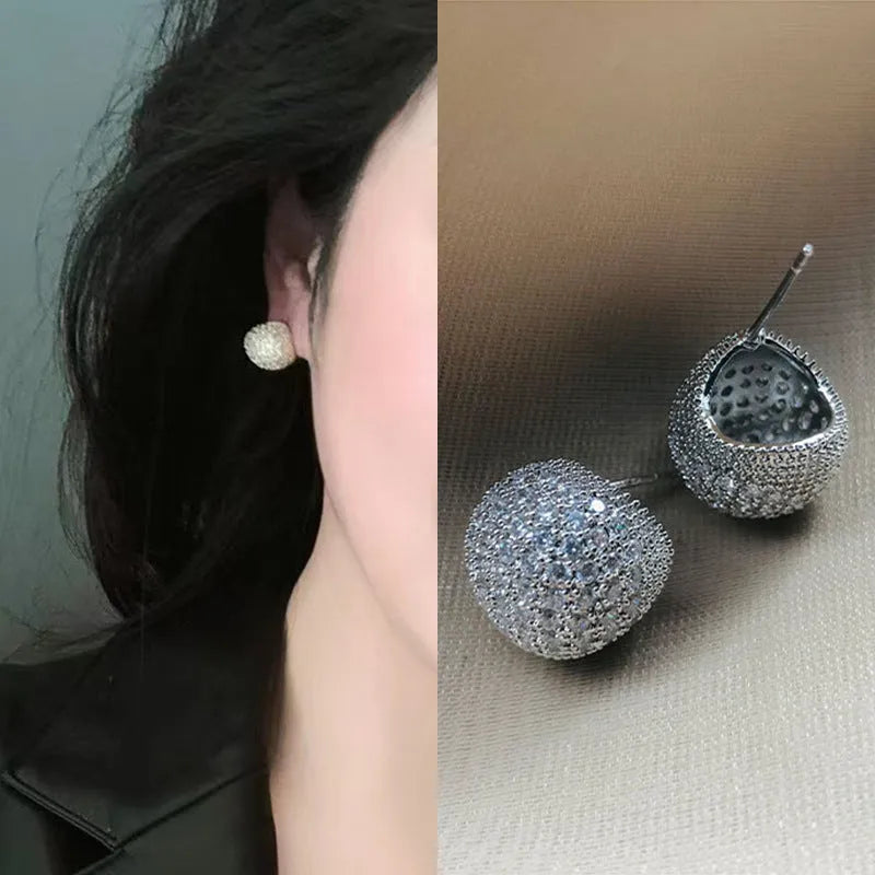 Gold or white geometric drop-shaped clip earrings with spherical bead elements