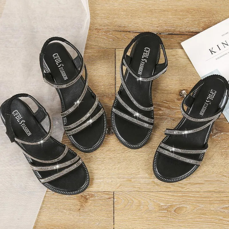 Women's silver flat sandals with round toe, rhinestone decoration, and elastic band on a non-slip rubber sole.