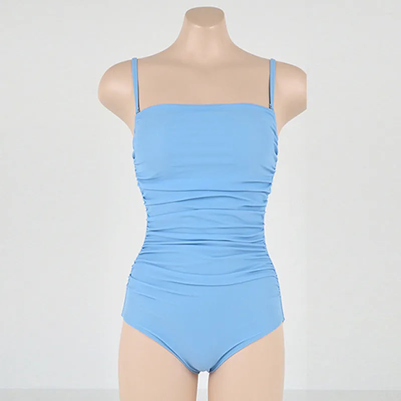 Sling style belly pleated one-piece swimsuit in solid color nylon and spandex blend for spring bathing