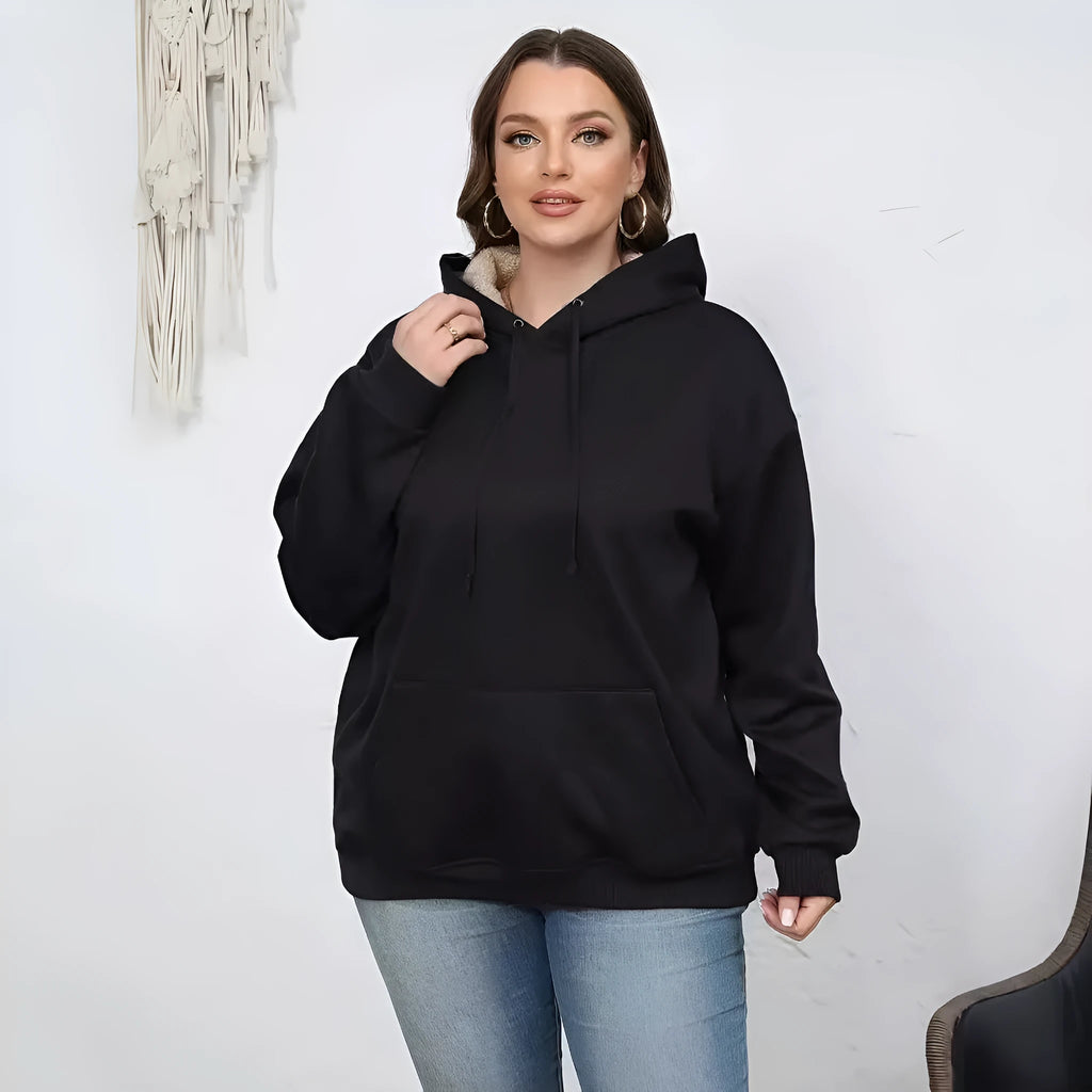 Woman wearing a thick grey hooded sweater with a 3D pattern and front pockets