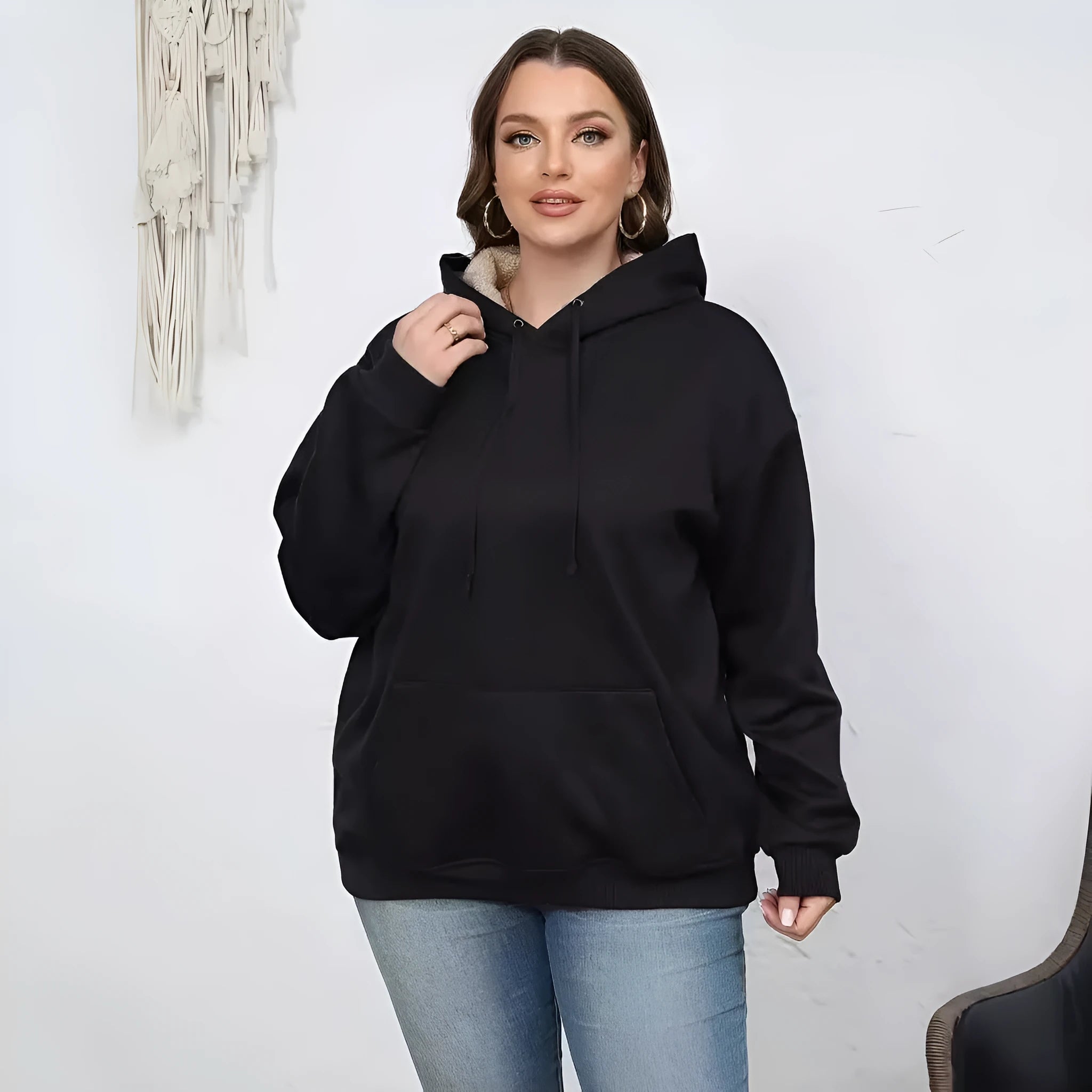 Woman wearing a thick grey hooded sweater with a 3D pattern and front pockets