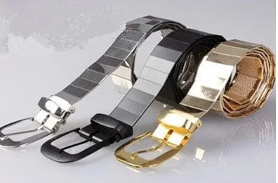 Three shiny belts in gold, silver, and black metallic finish arranged together