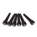 Six matt black ebony guitar string nails for folk acoustic guitars on a white background.