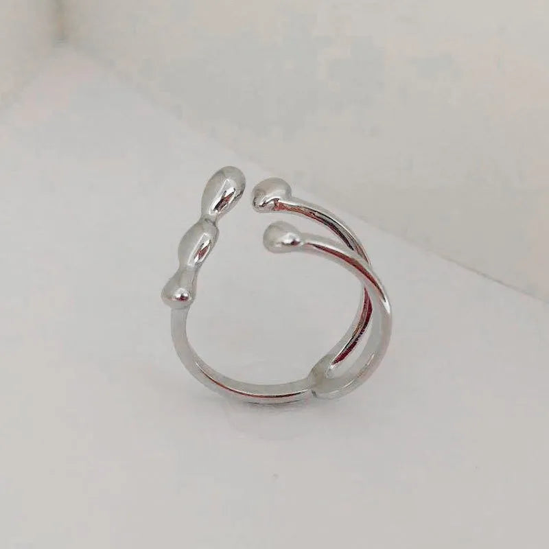 Brass opening ring with spherical details in gold or silver colour on display surface