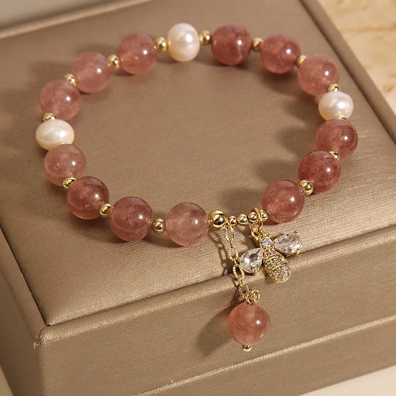 Women's bracelet with three freshwater pearls, a pink strawberry quartz charm, and sparkling zircon stones on an alloy chain.