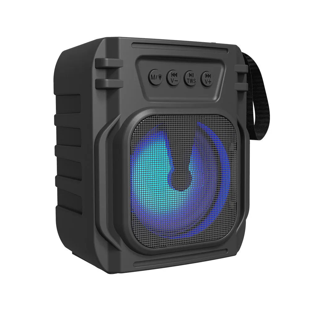 Compact portable Bluetooth speaker with USB charging cable on desktop