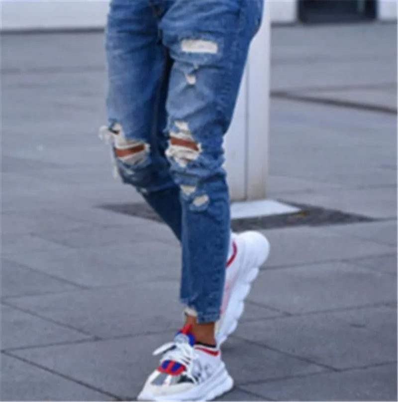 Men's blue jeans with distressed hole detailing on cotton fabric
