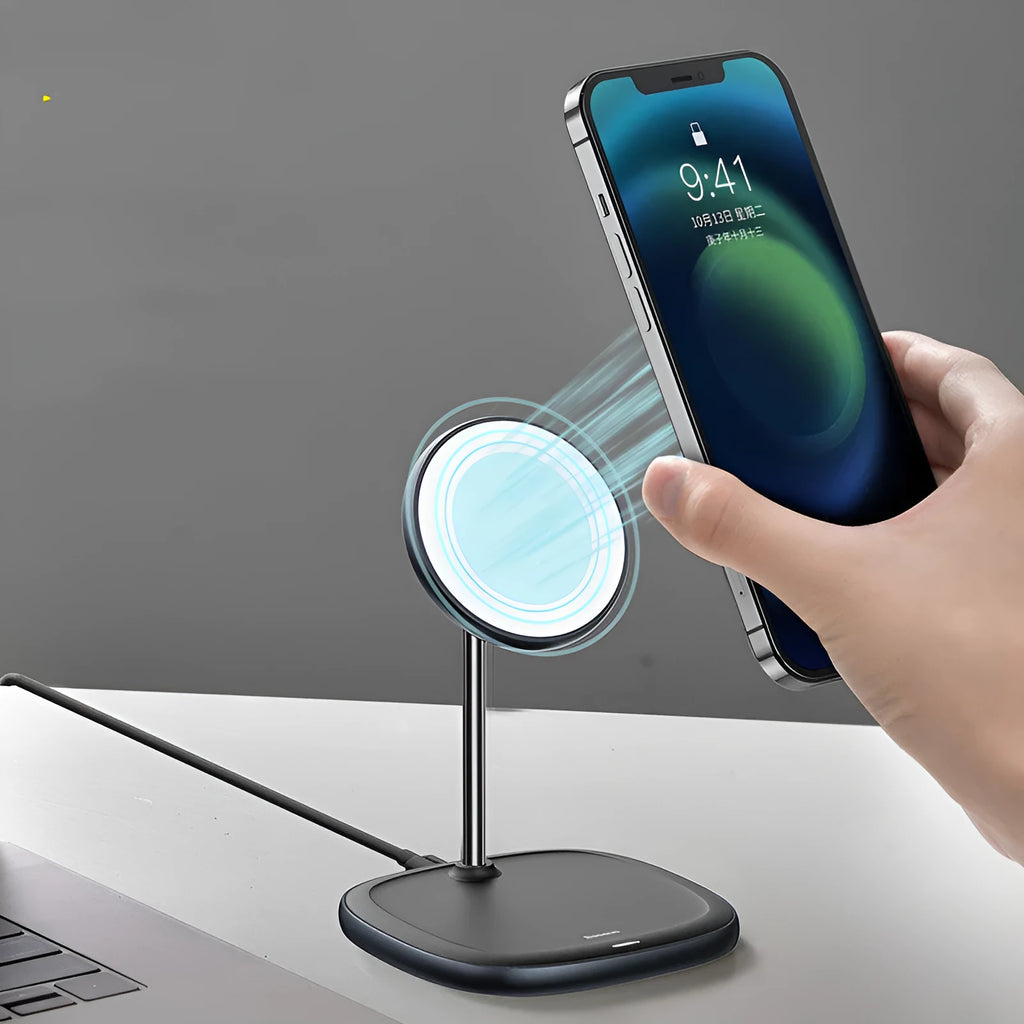 Black Swan magnetic wireless charging stand holding an iPhone 12 upright on a wooden desk.