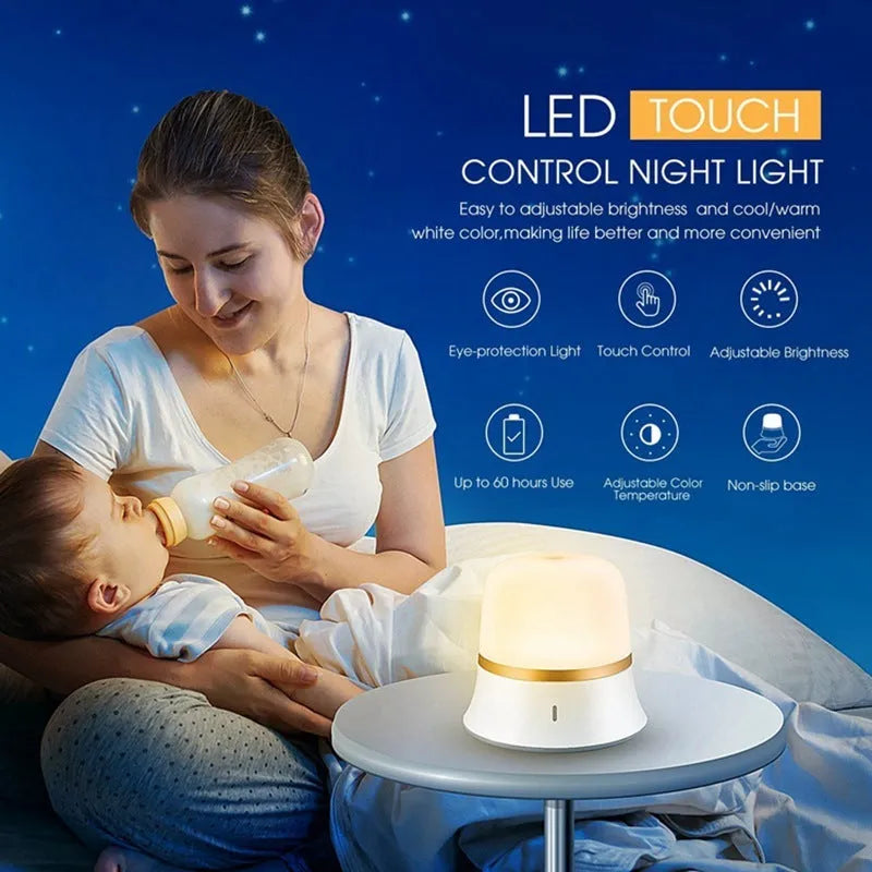 White cylindrical touch-control bedside night light with rechargeable battery on a table.