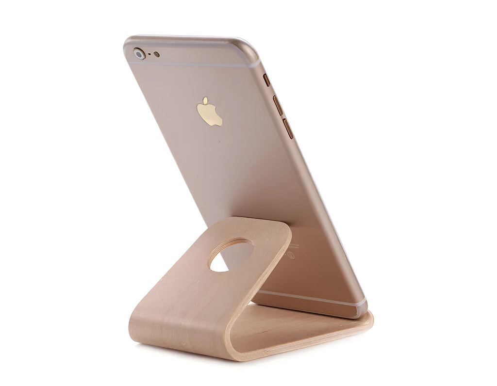 Solid walnut wooden iPhone stand holding a phone at an angle on a desk