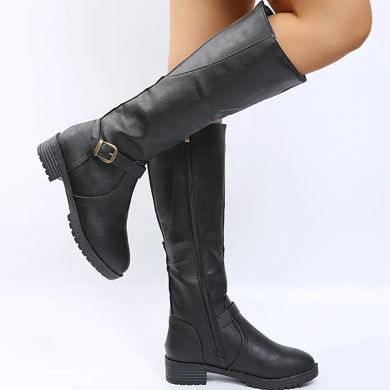 Women's black knight boots with belt buckle details and square heel on model