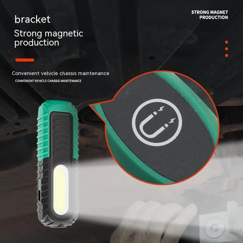 Black and green USB rechargeable automotive inspection work light on a workshop bench.