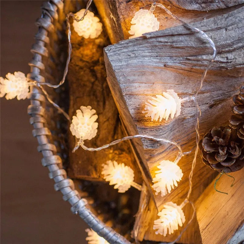 Battery powered LED pine cone light string in warm white colour with plastic shell construction