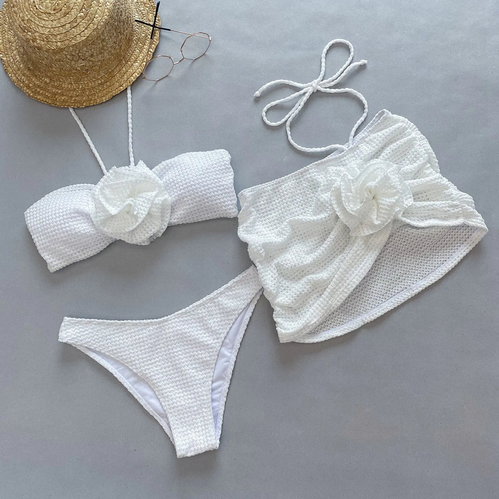 White women's three-piece bikini set with 3D flower split design on a mannequin.