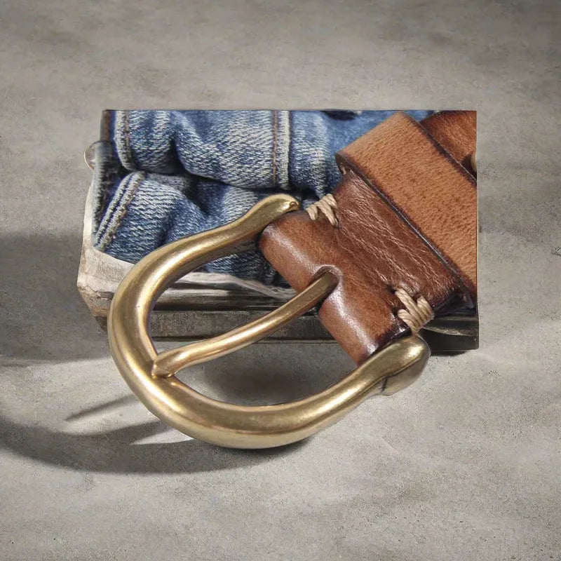 Men's brown leather belt with copper pin buckle on a pair of jeans.