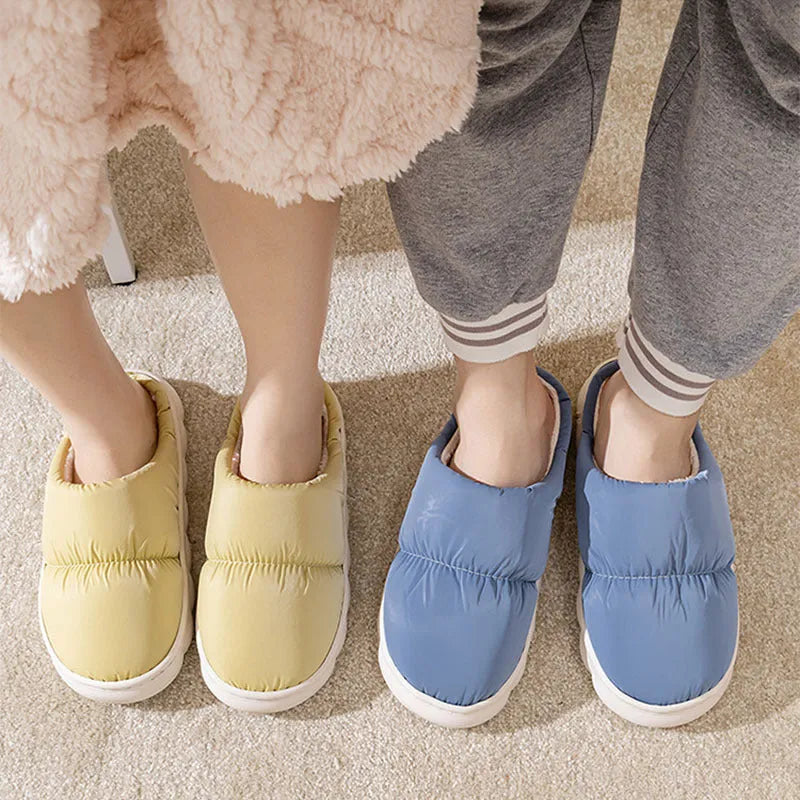 Pair of down cotton winter slippers with artificial leather upper, plush lining, and thick rubber sole.
