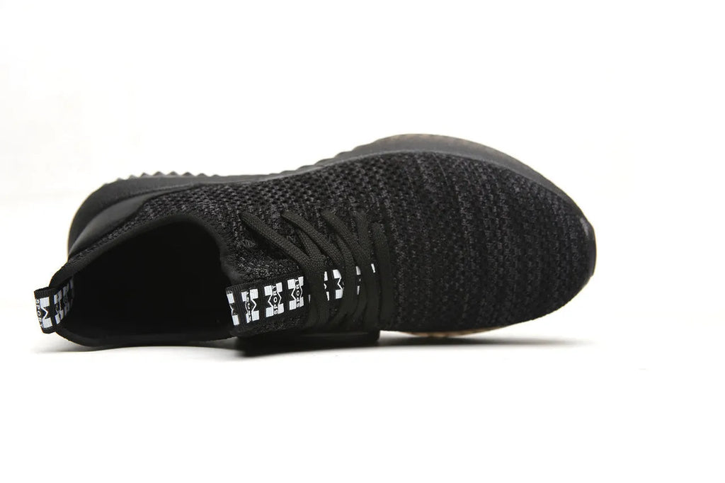 Black low-cut steel toe safety shoes with anti-static EVA sole on a work surface