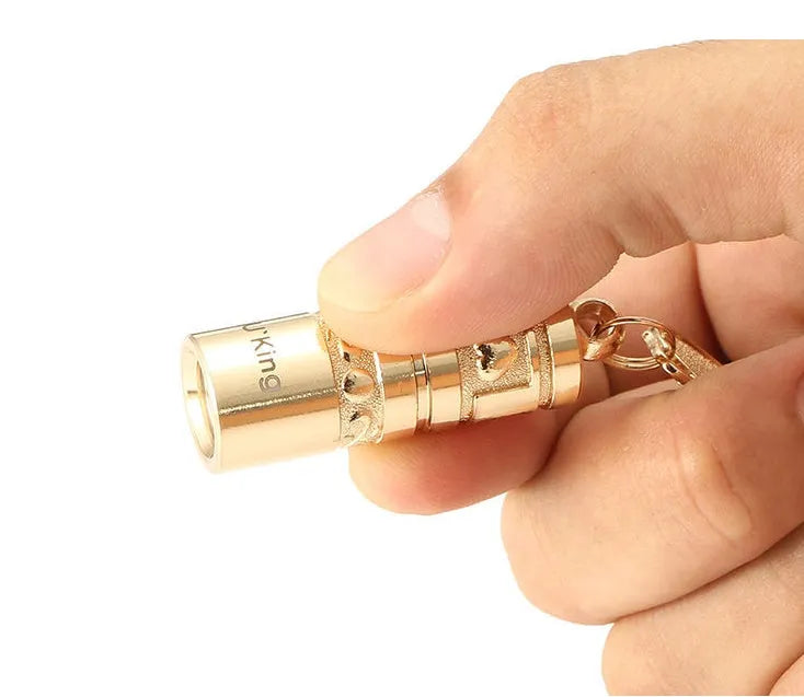 Gold zinc alloy waterproof LED keychain flashlight on a keyring.