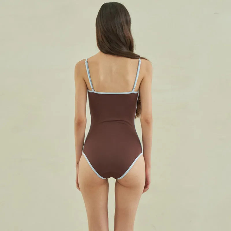 Brown triangle one-piece swimsuit for women on a hanger, showing sexy style and nylon fabric.