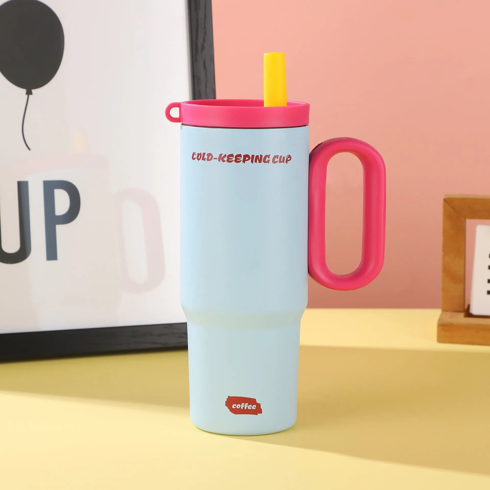 Insulated tumbler cup with a carrying handle and a straw, shown in one of five colour options.