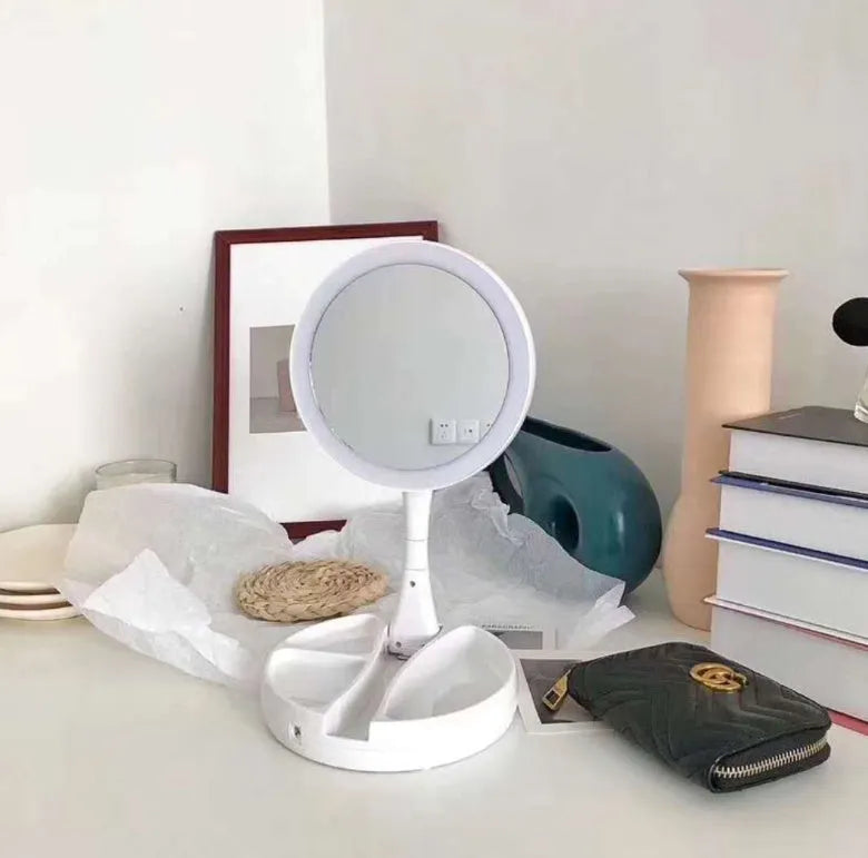 White foldable LED vanity mirror with a ring light, shown open on a table.